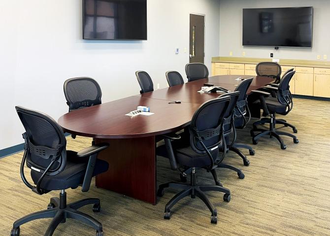 Photo of the Conference Room with 11 chairs around a conference table